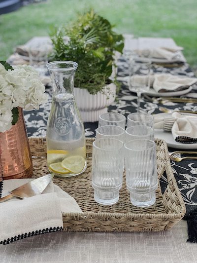 woven tray with glasses and hydrangea